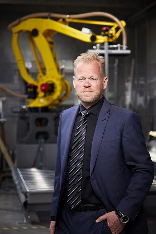 Henrik Anker foran en robot